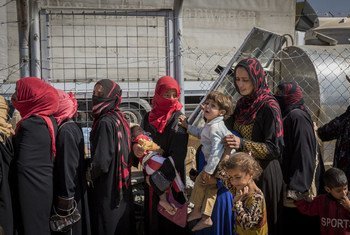 Displaced Iraqi women line up to receive food and water at Debaga camp for internally displaced people in Iraq’s Erbil Governorate.