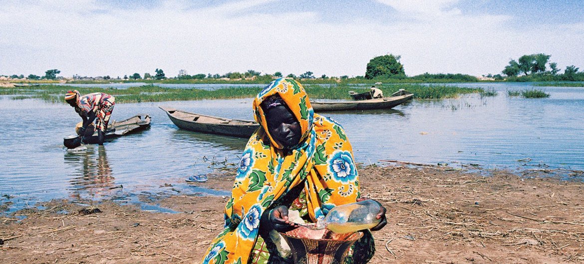 In the Liptako-Gourma region, Niger, an area that has experienced large-scale land degradation and water scarcity, a villager takes extra precautions to keep her supply of water clean.