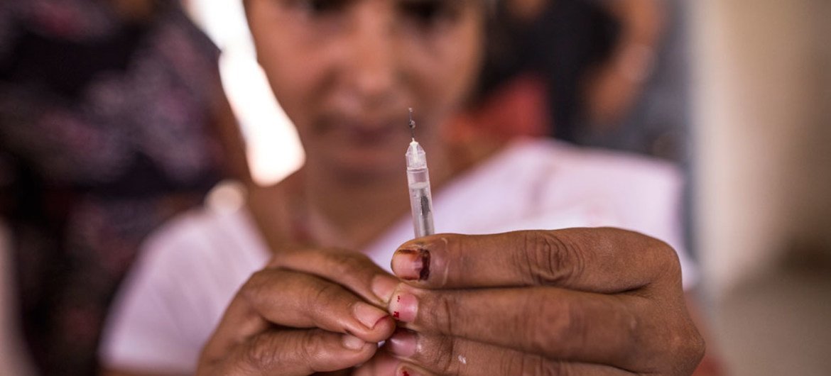 An Auxiliary Nurse Midwife prepares vaccine inside Anganwadi centre in Begusarai, Bihar, India.