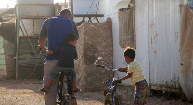 Un padre y su hijo se preparan para montar en bicicleta en la ciudad jordana de Mafraq.