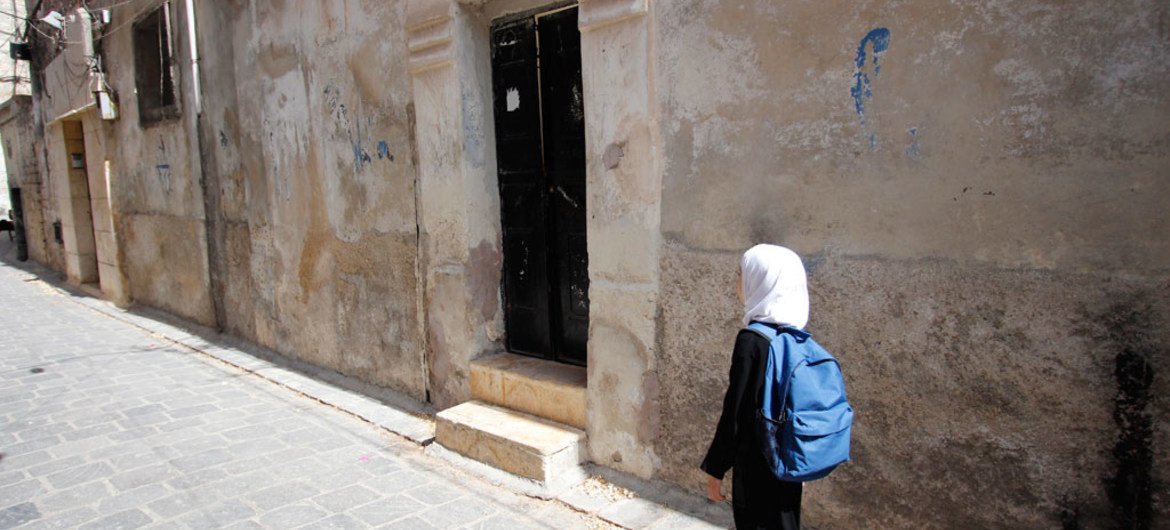 In eastern Aleppo, a young girl returns home from school.