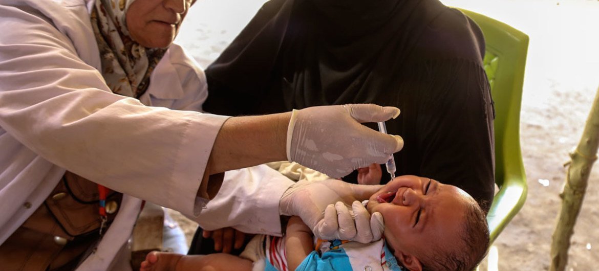 Ребенок в лагере для внутренних переселенцев в Ираке получает вакцину от полиомиелита. Фото ЮНИСЕФ/Ватиг Хузаи