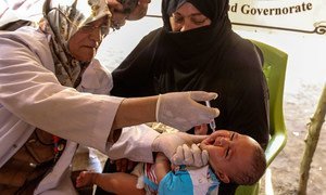 A medical worker gives a child two drops of oral polio vaccine at a temporary medical centre in Bzebiz Displacement Camp, Baghdad, Iraq.