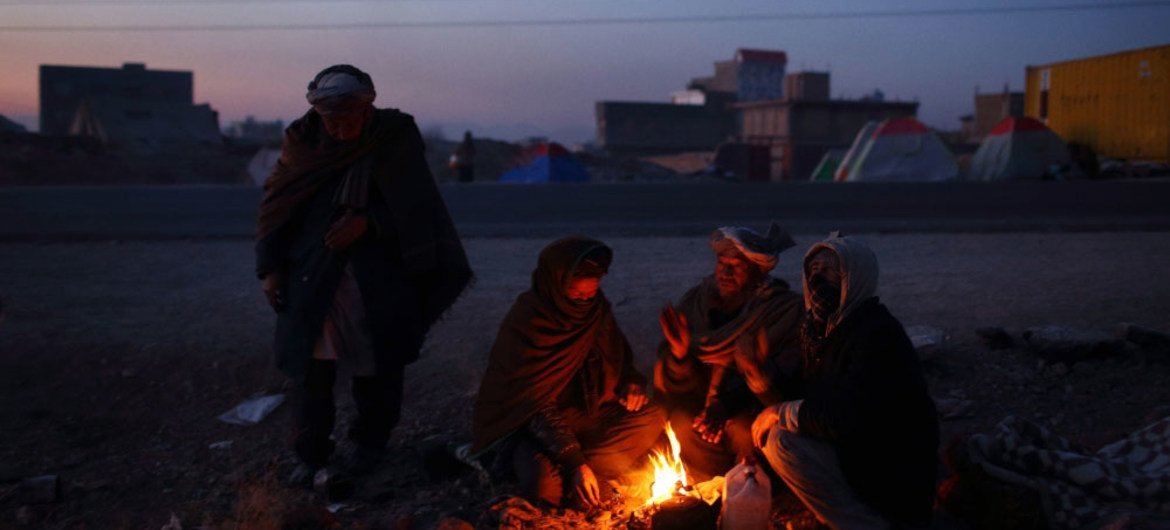 Families from Ghor Province, Afghanistan, gather by fires to stave off cold temperatures. About 300 people are living in makeshift shelters and tents after fleeing their homes due to fighting and drought, which ruined their harvests.