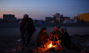 Des familles de la province de Ghor, en Afghanistan, se réunissent autour d'un feu pour lutter contre le froid. Environ 300 personnes vivent dans des abris et des tentes de fortune après avoir fui leur maison en raison des combats et de la sécheresse.