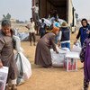 نازحون داخليا يتلقون مساعدات غذائية في القيارة بالقرب من الموصل.