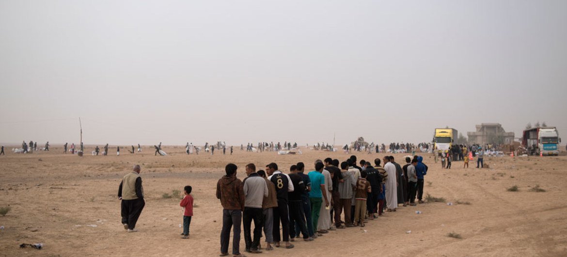 عراقيون فروا من القرى الواقعة جنوب الموصل يتلقون مساعدات إنسانية من وكالات الأمم المتحدة.
