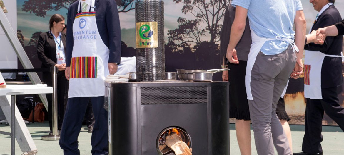 Secretary-General Ban Ki-moon (left) stands behind one of the fuel-efficient cook stoves used in the demonstration of sustainable cooking at the UN Climate Change Conference in Lima, Peru, in December 2014.