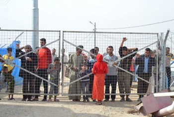 Men are detained behind the fence of the holding site in Debaga camp, Iraq. They are visited by their wives and children as they wait for Kurdish security to complete their investigation and clear them of Islamic State of Iraq and the Levant (ISIL/ISIS or Da’esh) links.