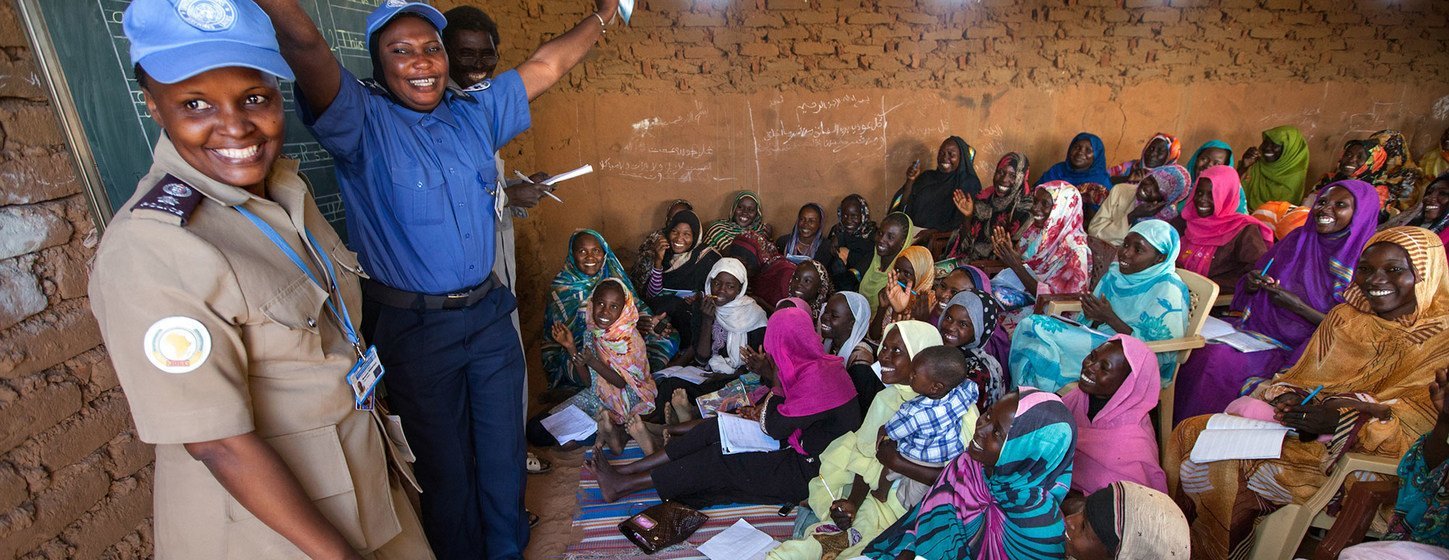 UN police officers Mwamini Rwantale (Tanzania) and Nyima Barrow (Gambia) interacting with women who receive English classes in the Abu Shouk camp for internally displaced persons in North Darfur. 