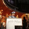 A man in a UN peacekeeper uniform speaks at a podium labeled 'Petit Palau' in a large hall.