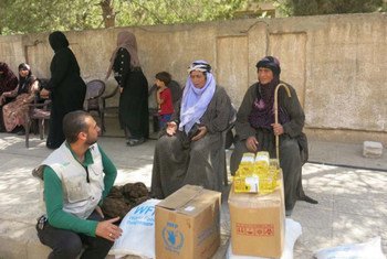 Widows in Qamishly, Syria, speak with a WFP programme officer at a food distribution centre. The majority of the women at the centre have been displaced multiple times because of conflict, often fleeing with nothing.