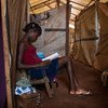 Une jeune fille lit un livre dans un abri de fortune dans un camp de déplacés à Bangui, en République centrafricaine (archives). Photo UNICEF/Tanya Bindra