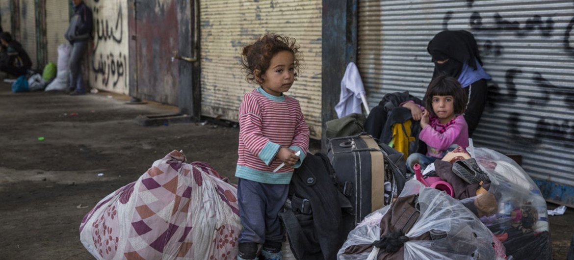 فتاة صغيرة تقف قرب ممتلكات عائلتها في حي كوكجلي الموصل  في انتظار الجيش العراقي لنقلهم الى مخيم للمشردين داخليا. المصدر: مفوضية الأمم المتحدة لشؤون اللاجئين / ايفور بريكيت