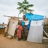 أم وأطفالها أمام مكان للاستحمام. المصدر: اليونيسف في أنغولا / 2016 / سيمانكاس