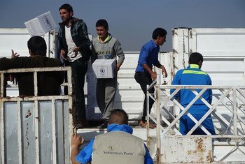 أرشيف: عمال يقومون بتحميل مساعدات برنامج الأغذية العالمي على شاحنة في الموصل. 