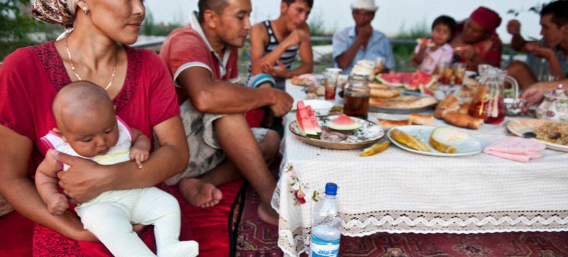 A farming family in Kyrgyzstan takes a break from the day's work to share a meal.