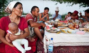 Фермерская семья в Кыргызстане за столом во время обеда. 