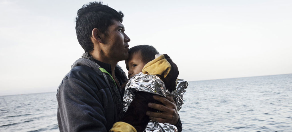一位阿富汗难民和孩子从土耳其乘坐皮划艇经爱琴海抵达了希腊的一个小岛。难民署图片/Achilleas Zavallis