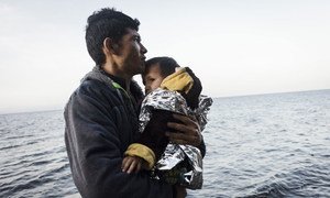 一位阿富汗难民和孩子从土耳其乘坐皮划艇经爱琴海抵达了希腊的一个小岛。