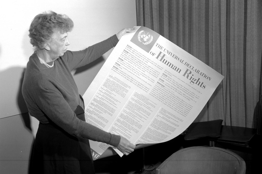 Eleanor Roosevelt des Etats-Unis tenant une affiche de la Déclaration universelle des droits de l'homme. Lake Success, New York, novembre 1949 