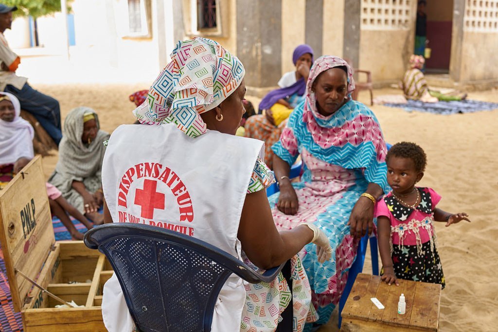 Une professionnelle de santé dans un village près de Kayar, au Sénégal, fournit des soins à des patients, dont des traitements contre le paludisme.