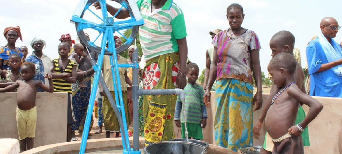 Des villageois à Kore, au Burkina Faso, collectent de l'eau à un point d'eau. 