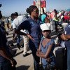 فتاة تنتظر مع عناصر من شرطة هايتي  وحدة العناية بالقصر في مدينة أوانامينت، على الحدود الشمالية الشرقية مع جمهورية الدومينيكان  المصدر: اليونيسيف / ماركو دورمينو