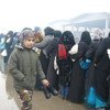 Exode depuis les quartiers est d'Alep: des femmes font la queue dans un abri temporaire à Al-Mahalej, Syrie, afin de recevoir du pain et un repas chaud. Beaucoup d'entre elles disent avoir vécu sur des tirs et bombardements constants.