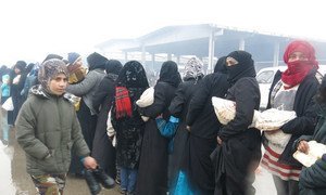 Exodus from eastern Aleppo city: Women line up at a temporary shelter in Al-Mahalej, Syria, to receive bread and hot meals. Many say they lived under constant shelling and bombardment.