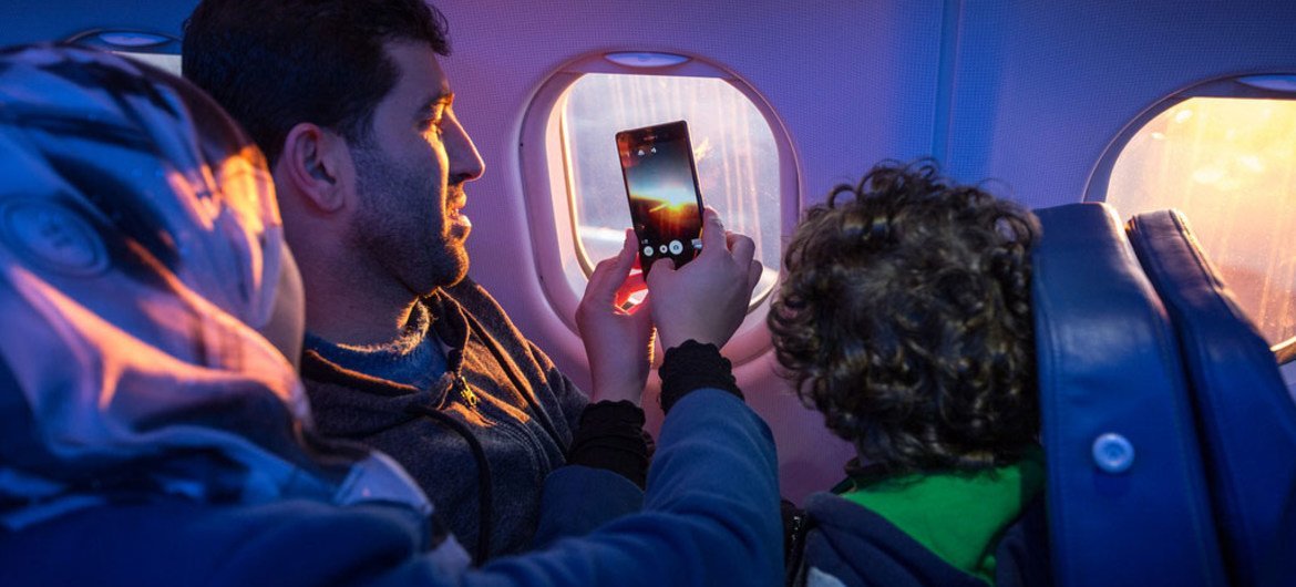 أسرة مهاجرة تلتقط صورة من الطائرة التي تقلها في رحلة الهجرة.
