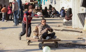 Children at a shelter in Jibreen, Aleppo, Syria, play with a cart.