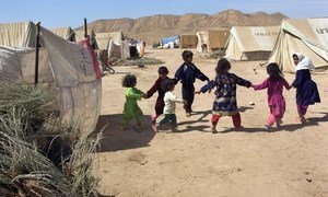 Des enfants jouent dans un camp pour personnes déplacées dans le nord de l'Afghanistan. Le camp inclue également des Afghans rapatriés de l'Iran voisin. (ARCHIVE - 30 août 2009). Sar-e-Pul, Afghanistan. Photo ONU/Eric Kanalstein.