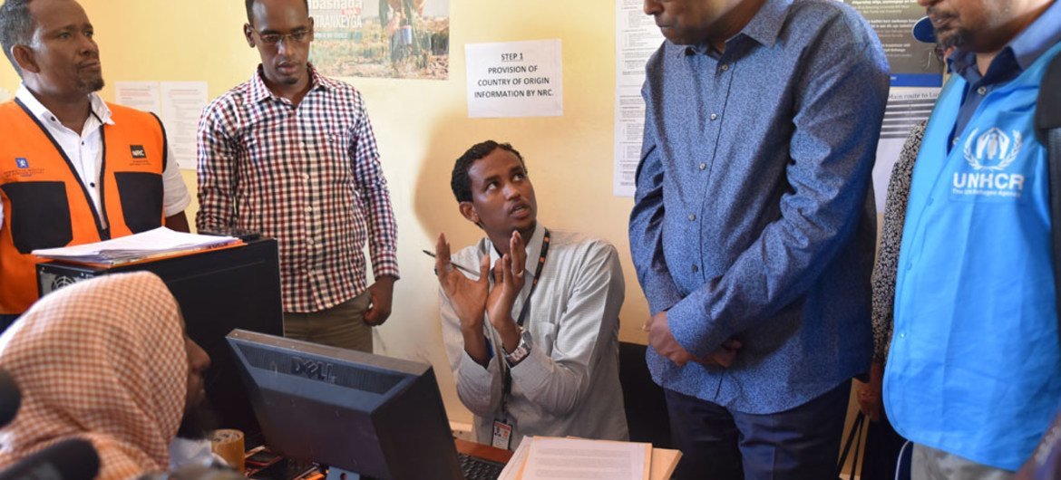 L'Envoyé spécial du HCR, Mohamed Abdi Affey (second à partir de la droite) écoute un réfugié somalien à Dadaab, au Kenya, qui a choisi de rentrer à la maison via un programme de rapatriation volontaire.