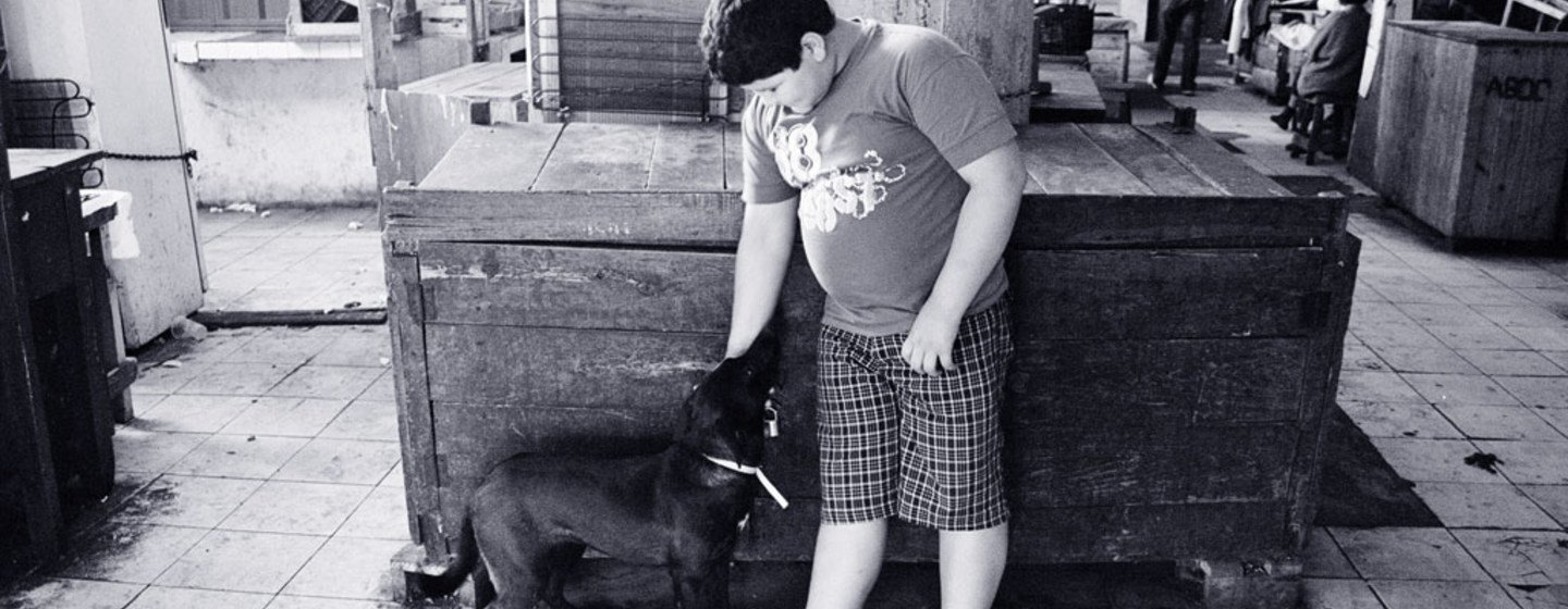 Un garçon en surpoids joue avec un chien à Asuncion, au Paraguay.
