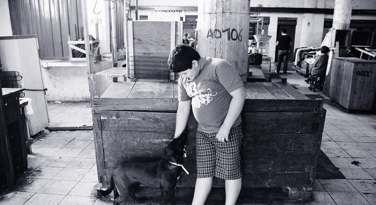 Un garçon en surpoids joue avec un chien à Asuncion, au Paraguay.