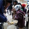 叙利亚阿勒颇的儿童正在从世界粮食计划署工作人员那里领取热餐食。粮食署图片