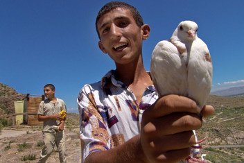 Kijana nchini Armenia akiwa ameshika njiwa, ndege ambaye ni alama ya amani. 