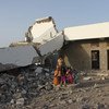 أطفال يجلسون أمام مدرسة تضررت بشدة في الصراع الدائر في اليمن
