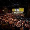 A wide shot of a large, dimly lit banquet hall filled with guests seated at round tables during the 13th UNWTO Awards ceremony.