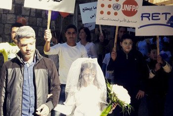 Девочка,  одетая  в  платье невесты, принимает участие в   марше протеста против  ранних браков и   насилия на  гендерное почве. Ливан. 