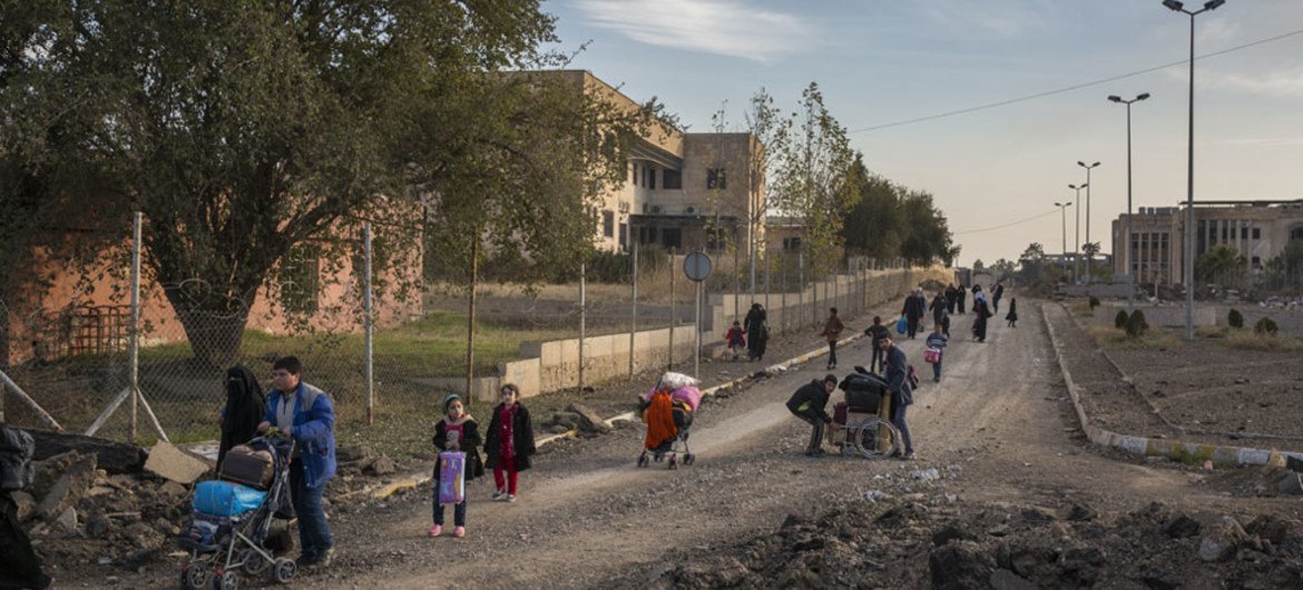 Iraqi families flee east Mosul through the recently liberated Mosul University complex.