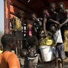 新抵达乌干达的南苏丹难民正从一辆卡车上下来。难民署图片/Michele Sibiloni