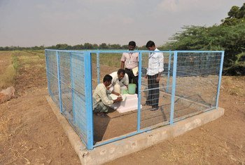 Members of an Indian farmers group measure local groundwater levels at an observation well.