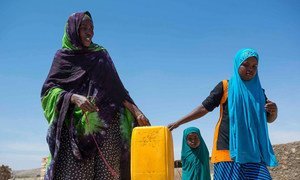 A resident of Rabaable village in Somalia fetches water with the help of her daughters. The villages well was recently rehabilitated by UNICEF.