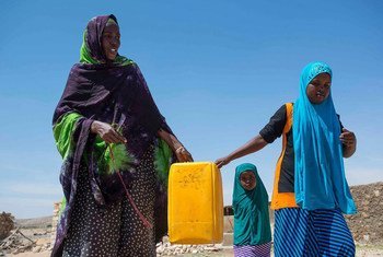 A resident of Rabaable village in Somalia fetches water with the help of her daughters. The villages well was recently rehabilitated by UNICEF.