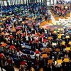 A large crowd of youth holds up colorful cards on a stage at the UN headquarters during the Global Ideas competition.