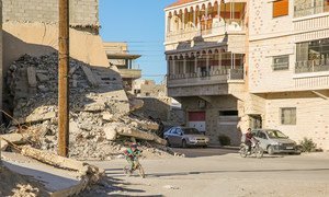 A boy cycles past the rubble of a destroyed house in Qara, where fighting erupted in 2014, dragging the town into the brutal Syrian conflict.