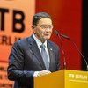 A man in a suit speaks at a podium at the ITB Berlin 2017 event.