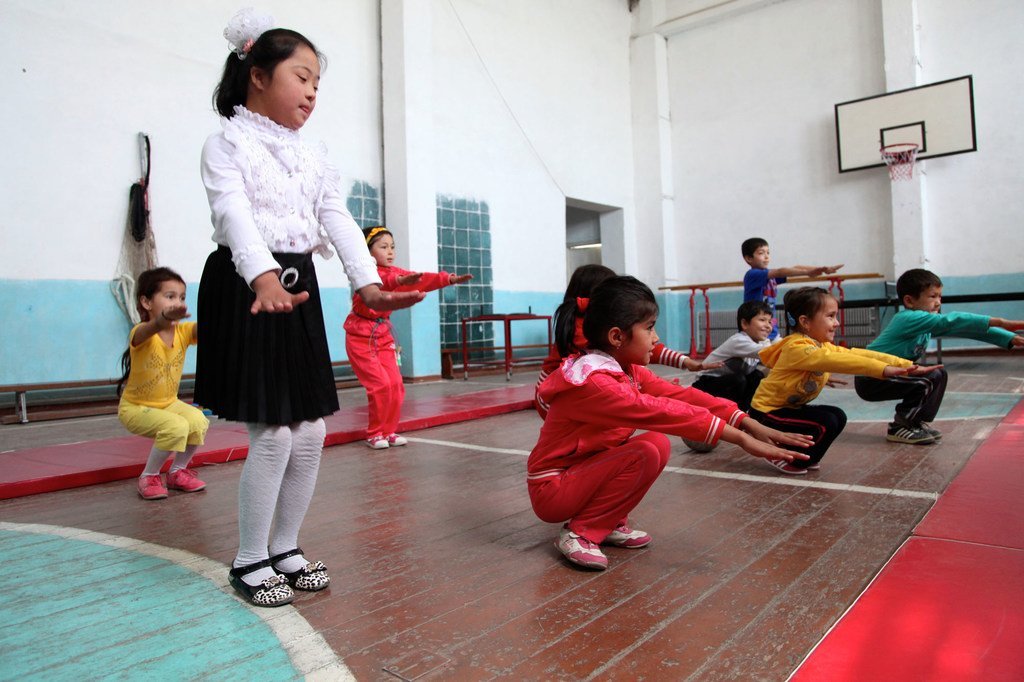 أطفال يقومون بتمارين جسدية في صالة ألعاب رياضية في أوزبكستان، من بينهم طفلة مصابة بمتلازمة داون. 